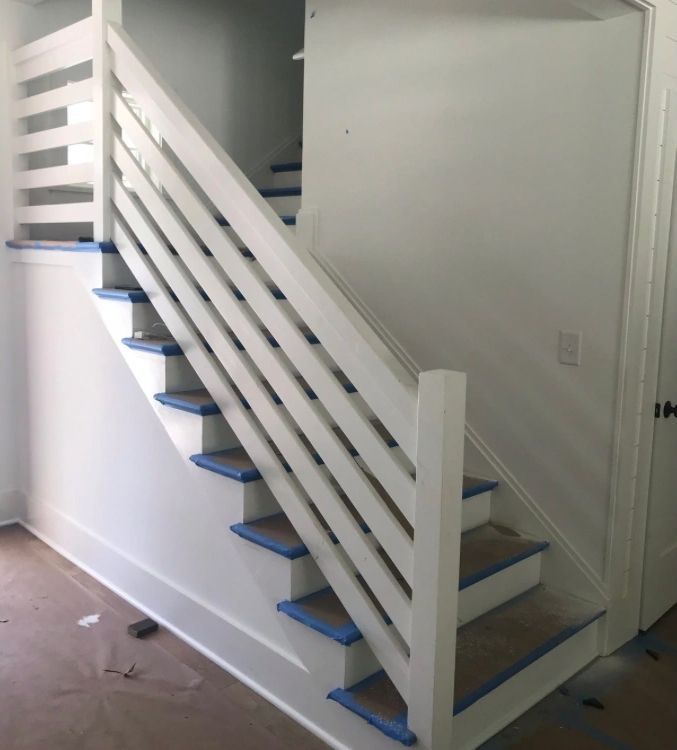 A white staircase with blue steps and a white railing