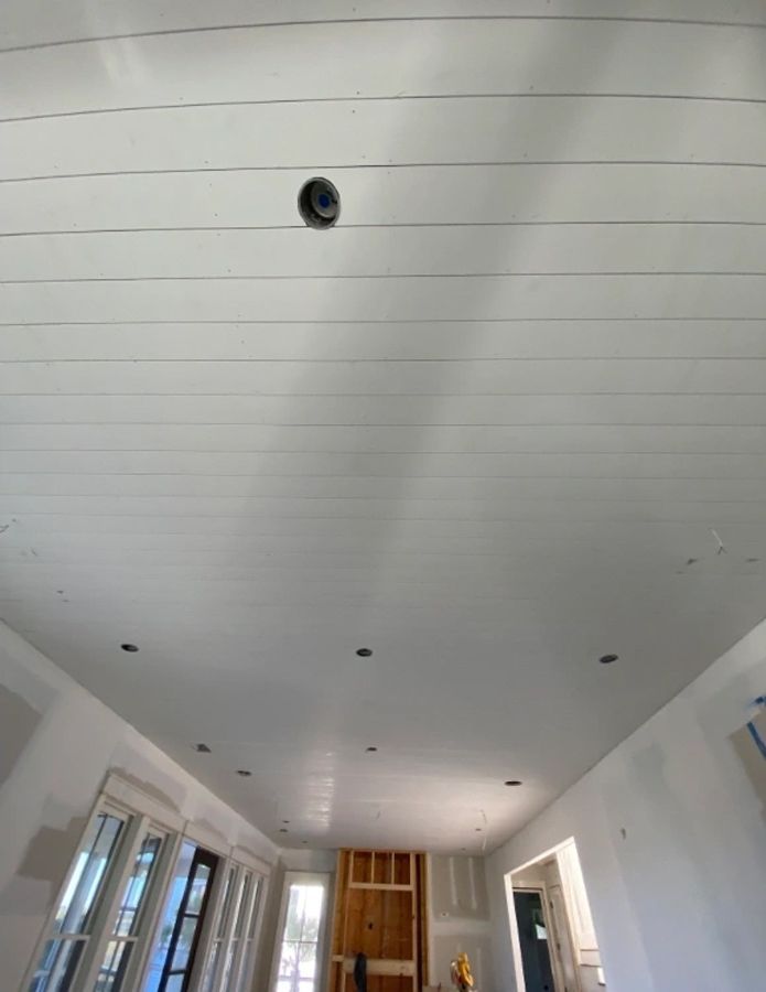 A white ceiling in a living room with a camera on it.