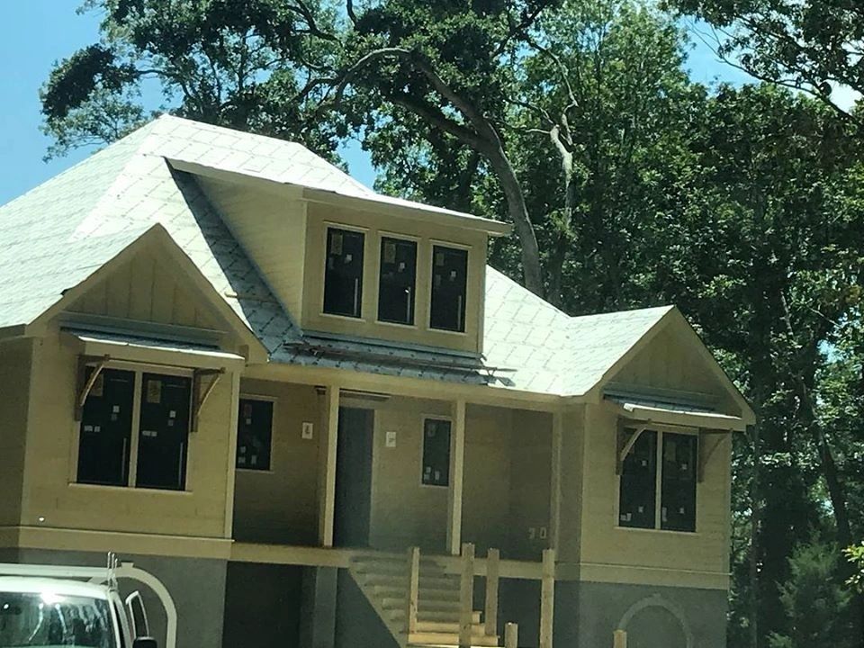 A house under construction with a truck parked in front of it