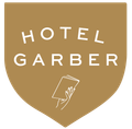 Hotel Garber logo in a gold shield; white text and hand holding papers.