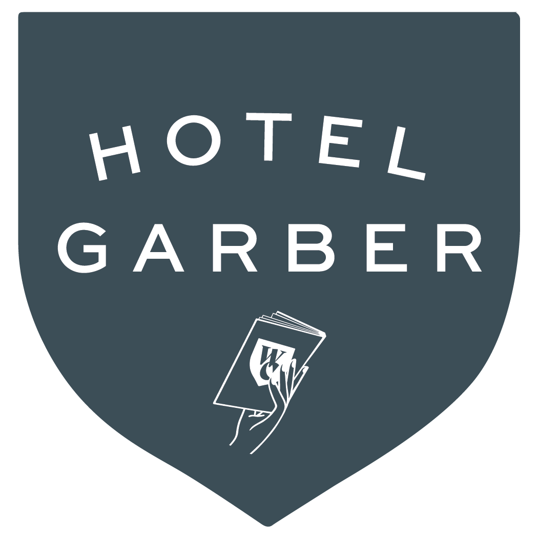 A logo for hotel garber with a hand holding a notebook