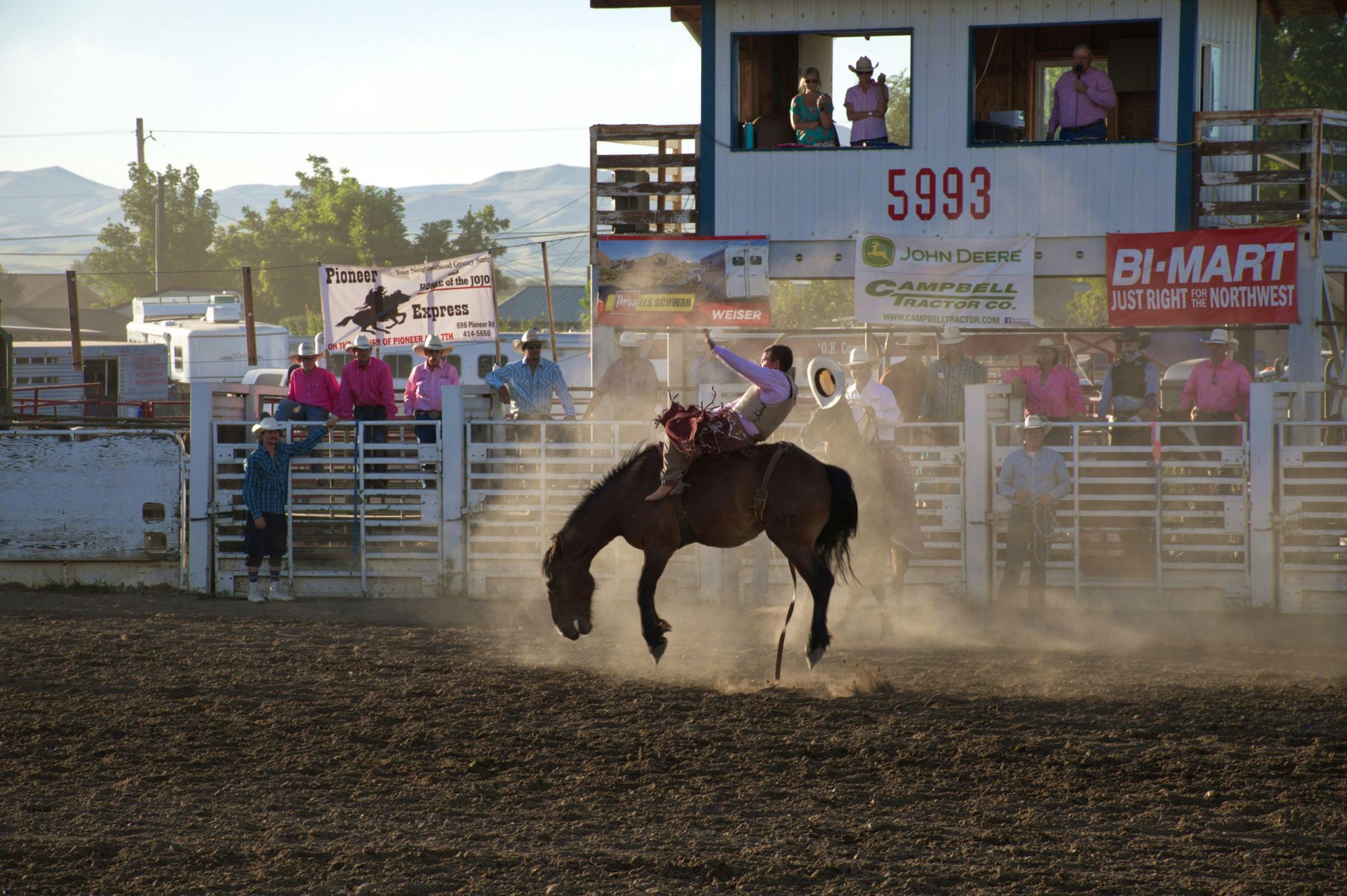 A man is riding a bucking horse at a rodeo