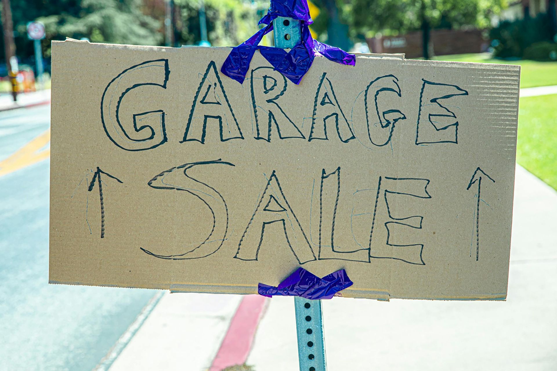 A cardboard sign that says garage sale on it