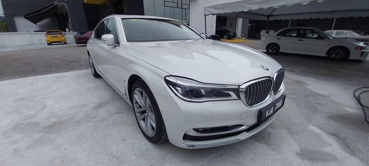White BMW sedan parked in a covered lot on a snowy surface
