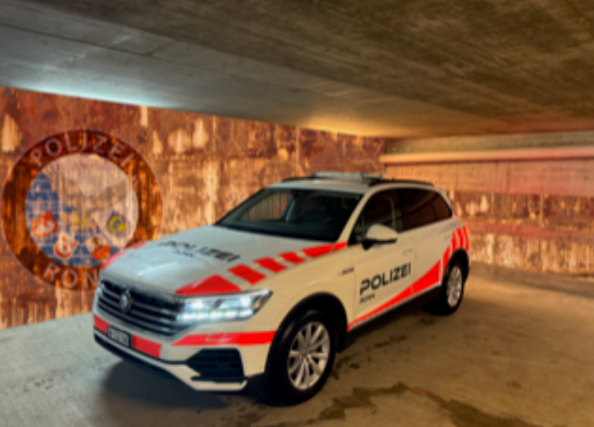 Ein weiß-rotes Polizeiauto steht in einer Garage