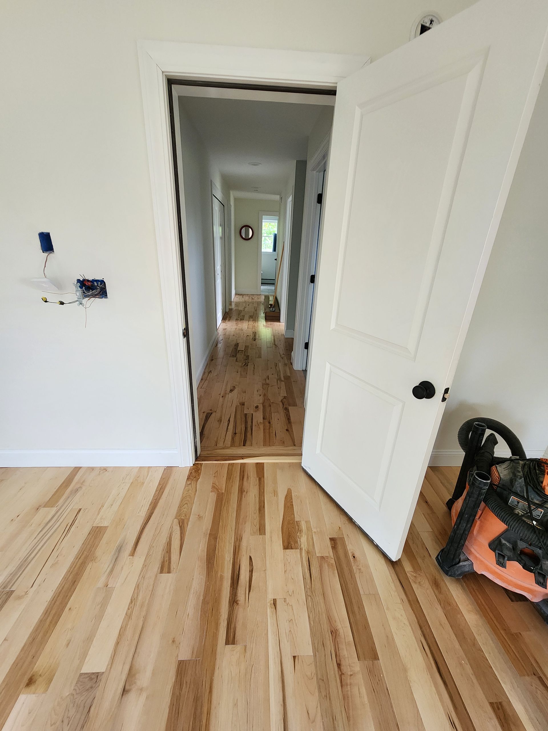 A light green HVAC unit stands in a dimly lit basement next to a water heater and a white washing machine.