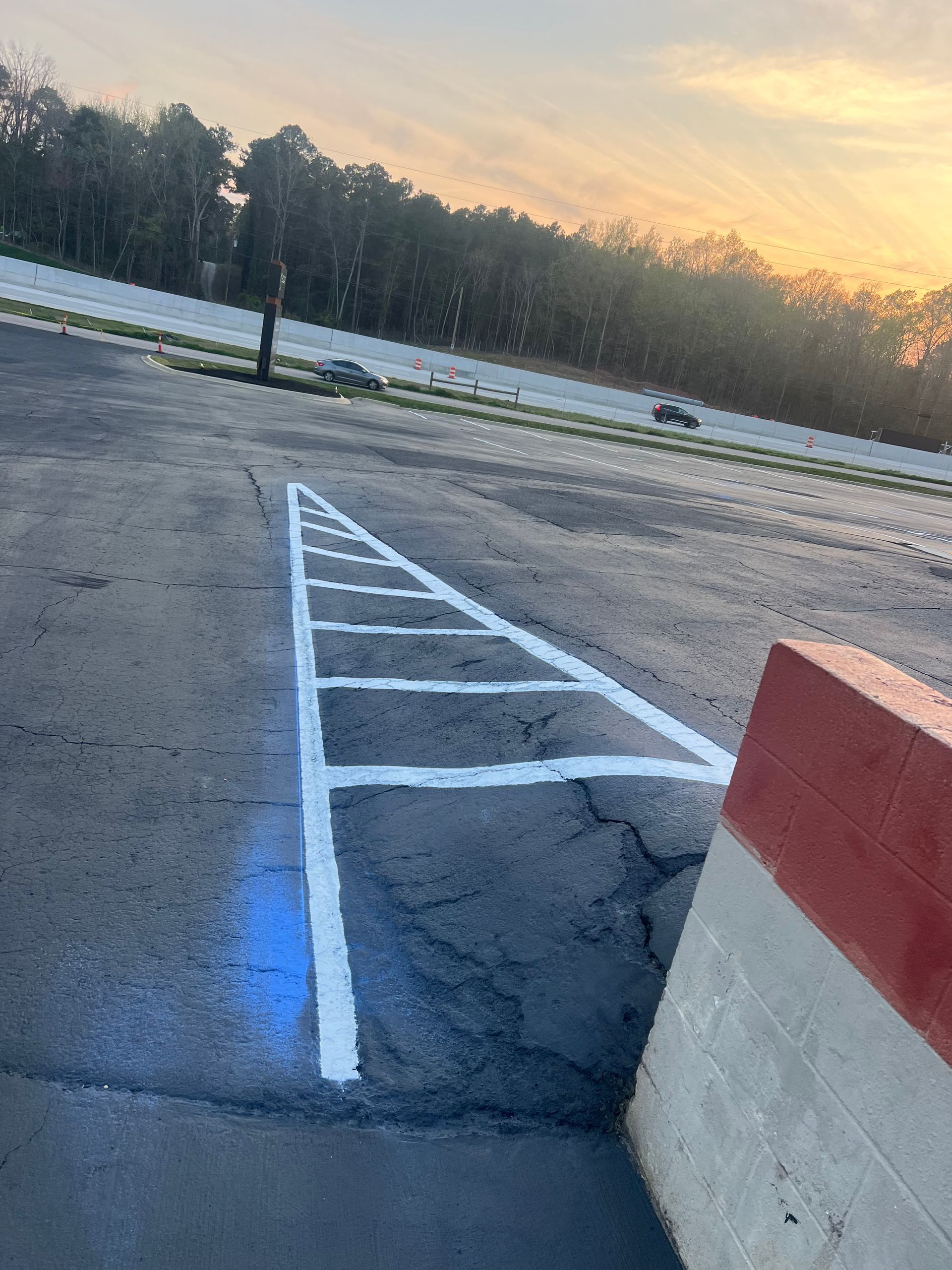 A parking lot with a handicapped parking space painted in the shape of an arrow.