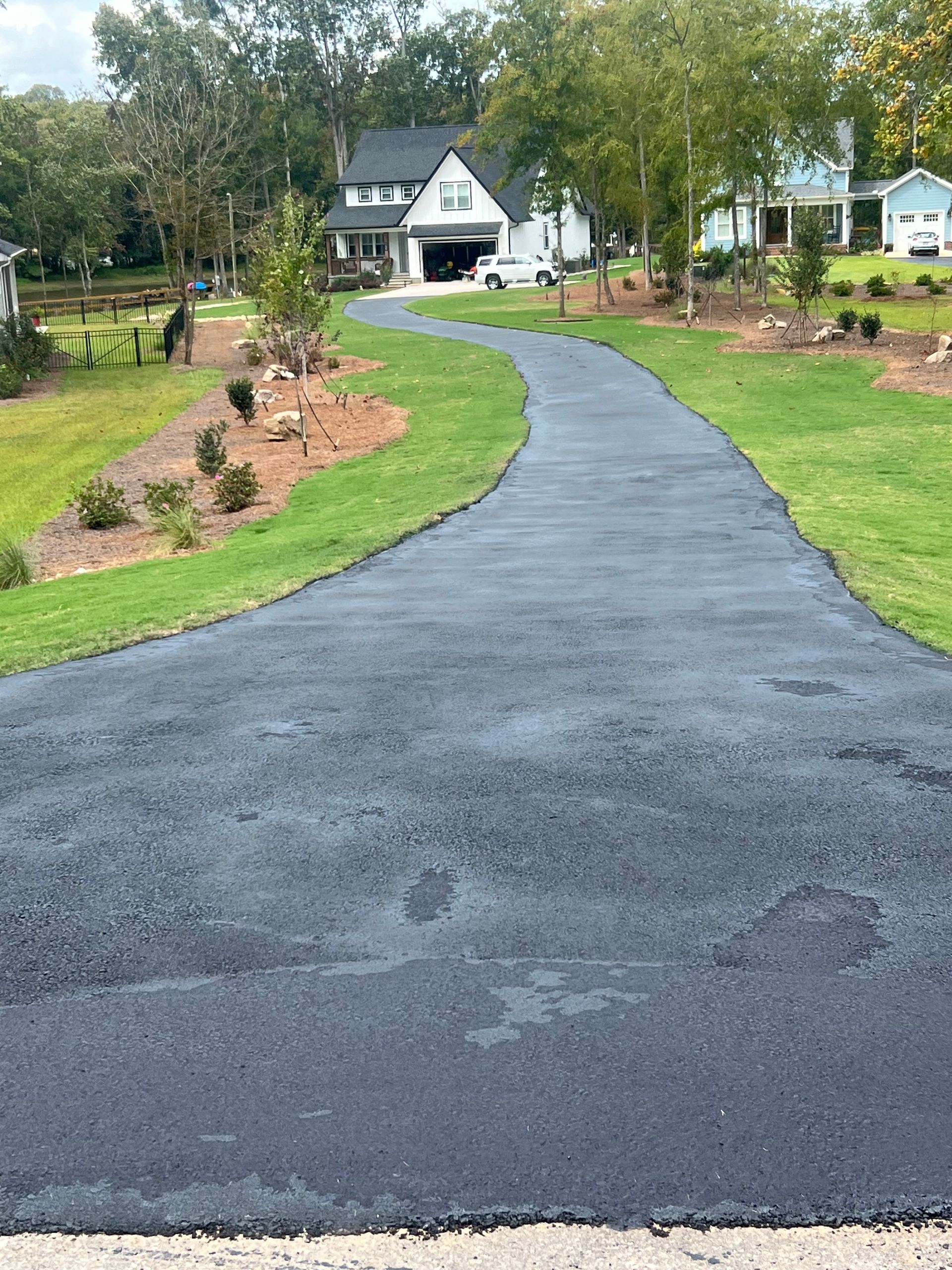 A newly paved driveway leading to a house.