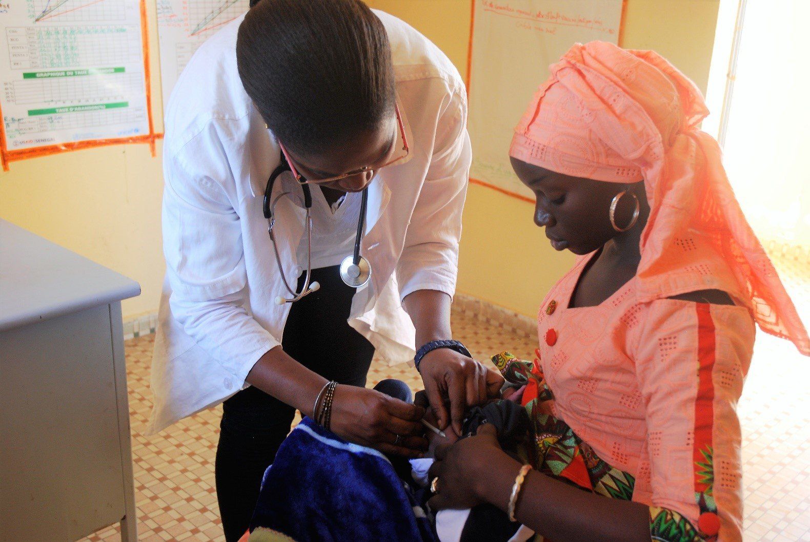 Aminata Diop, 32, nurse, health post manager giving injection 