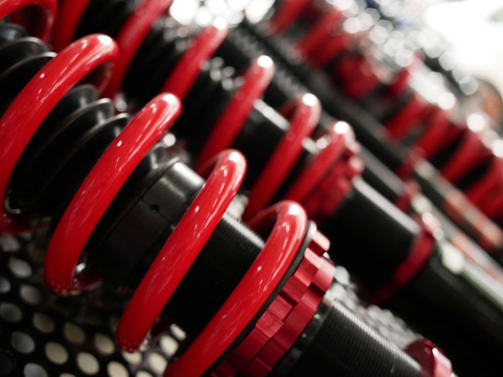 Red and Black Coil-over Shock Absorbers in a Row — Enterprise Auto Repairs in Kunda Park, QLD