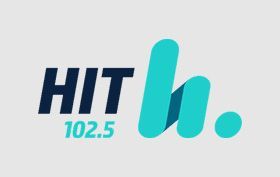 HIT 102.5 logo in navy and teal with a stylized lowercase h and dot on a light gray background