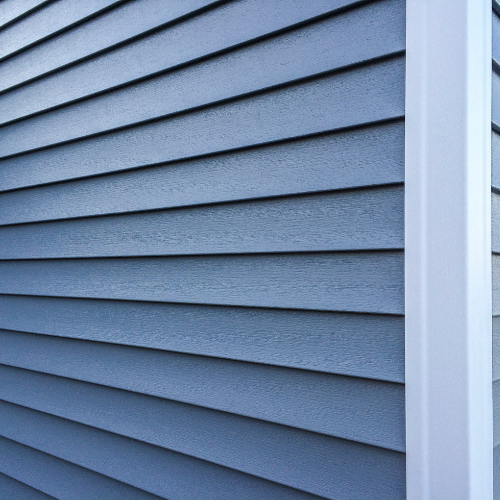 Blue siding on a building's exterior with a white trim column on the right side.