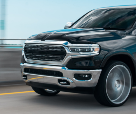 A black and silver truck is driving on a bridge | Ed's Automotive