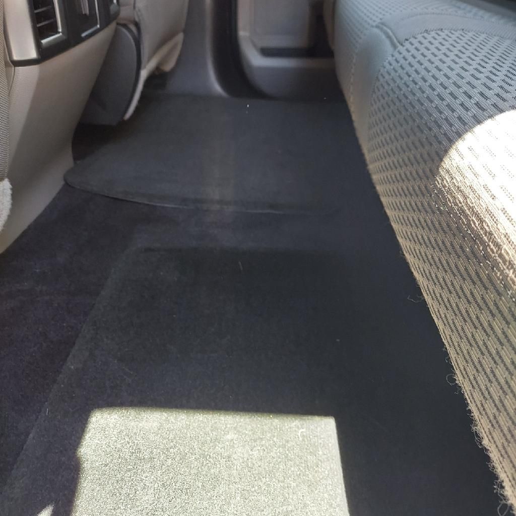The back seat of a car with a carpeted floor | Ed's Automotive
