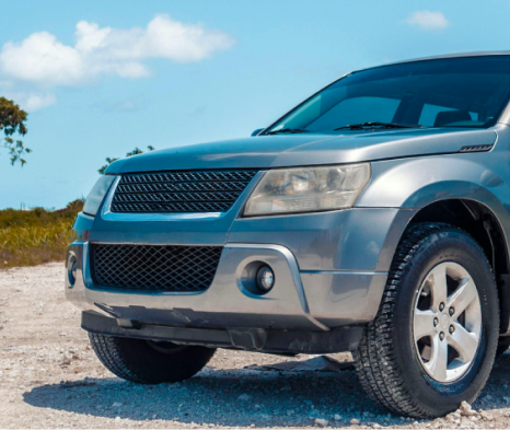 A silver suv is parked on a dirt road | Ed's Automotive