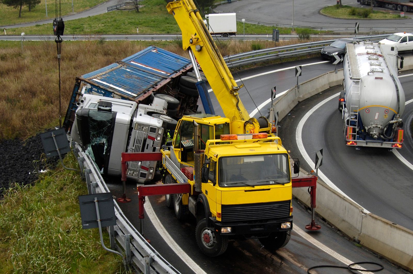 A yellow truck with a crane attached to it