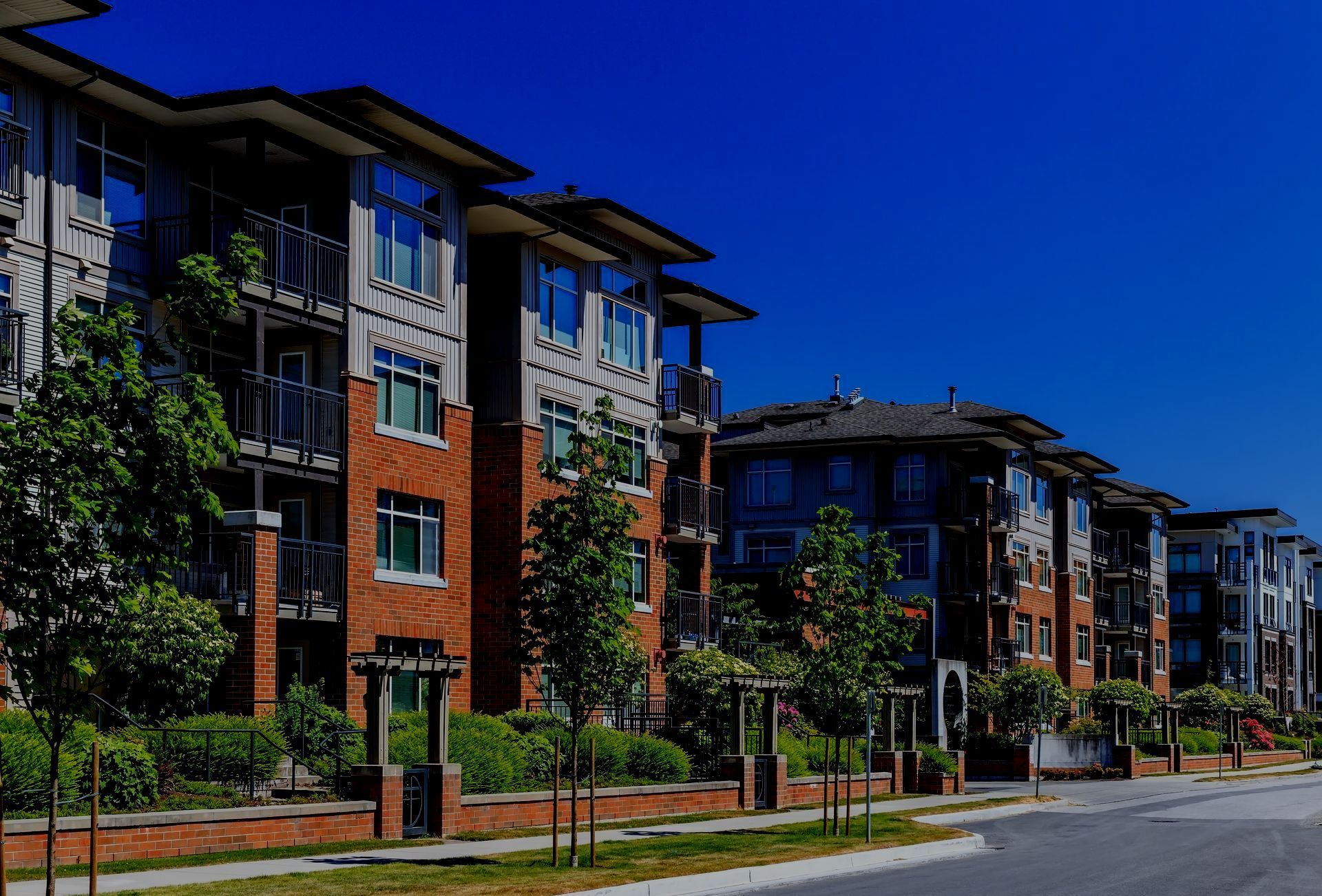 A row of apartment buildings are lined up next to each other on a sunny day.