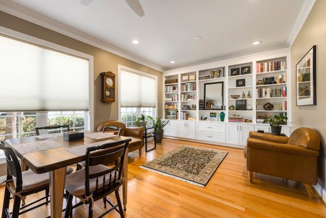 a kitchen and living room with hard wood flooring and sliding class doors to a patio