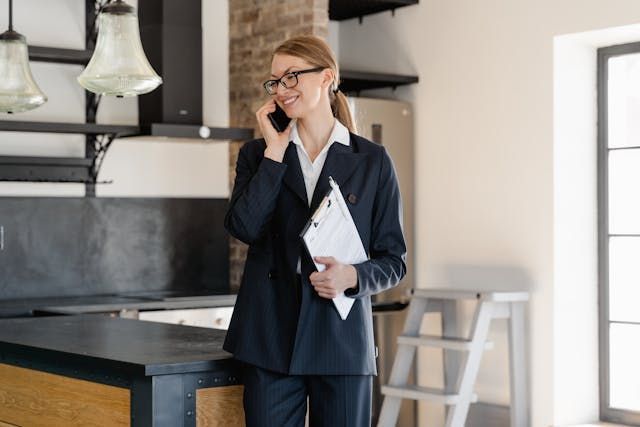 a landlord talking on the phone while holding a clipboard