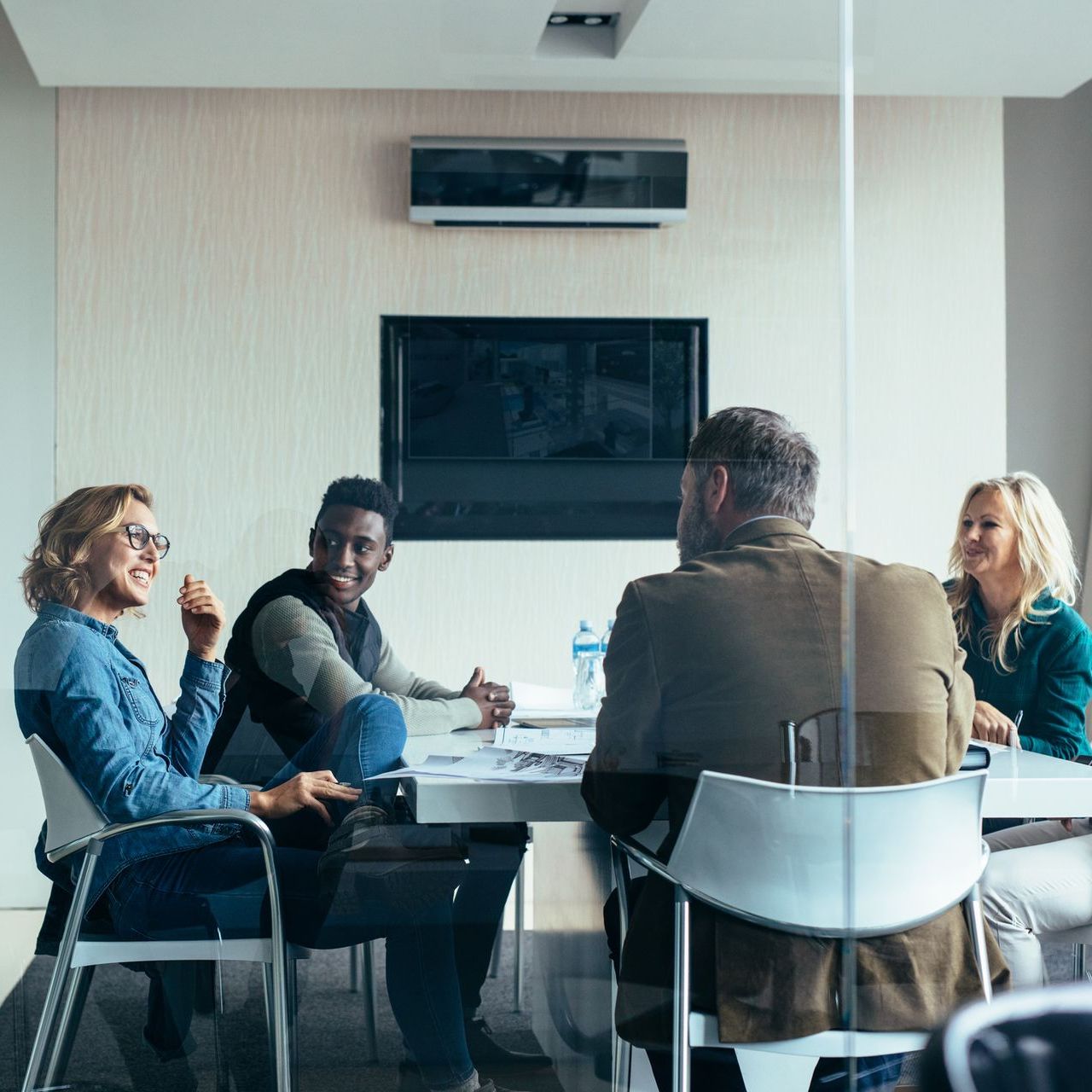 A group of people are sitting around a table in a conference room.