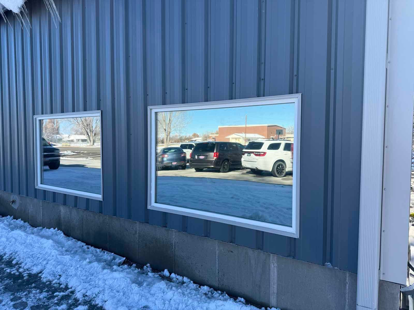 A building with a lot of windows and cars parked in front of it.
