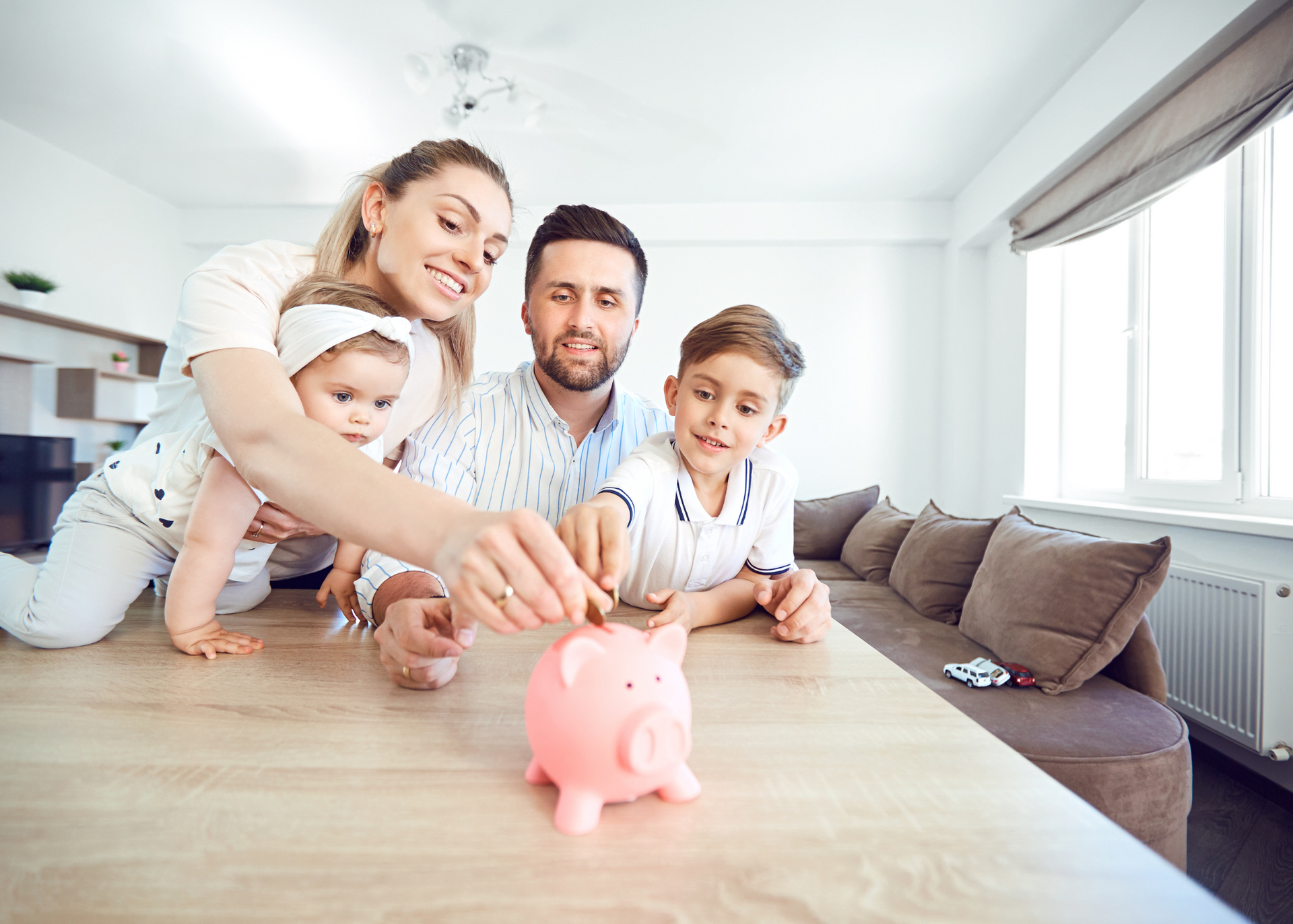 A young family saving money together at home, representing planning and investing through a self-man