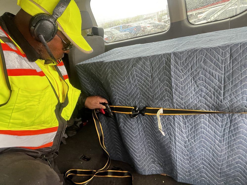A man wearing headphones is sitting in the back seat of a car.
