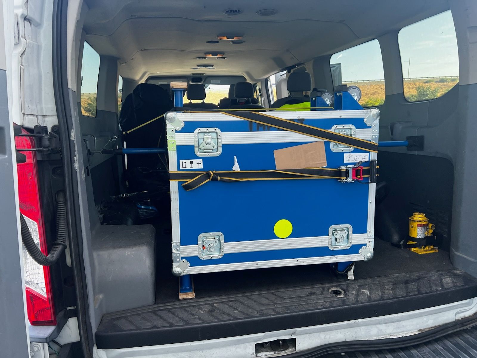 A white van with blue cases in the back of it.