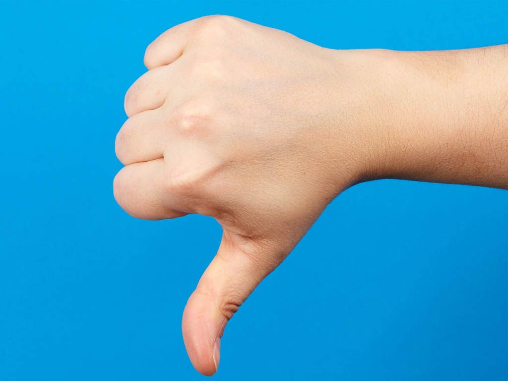 A hand is giving a thumbs down sign on a blue background.