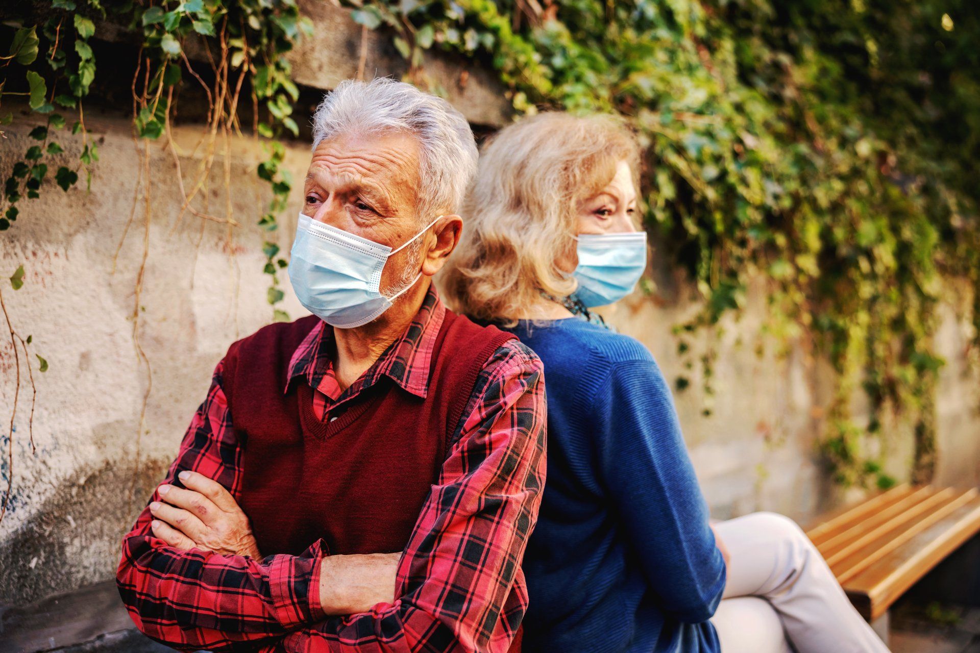 ouder echtpaar met mondkapjes op praten niet meer met elkaar en zitten met de rug naar elkaar toe