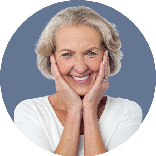 An older woman is smiling with her hands on her face
