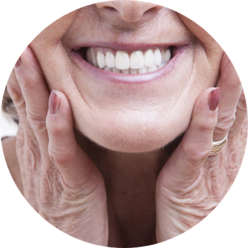 A woman is smiling with her hands on her face