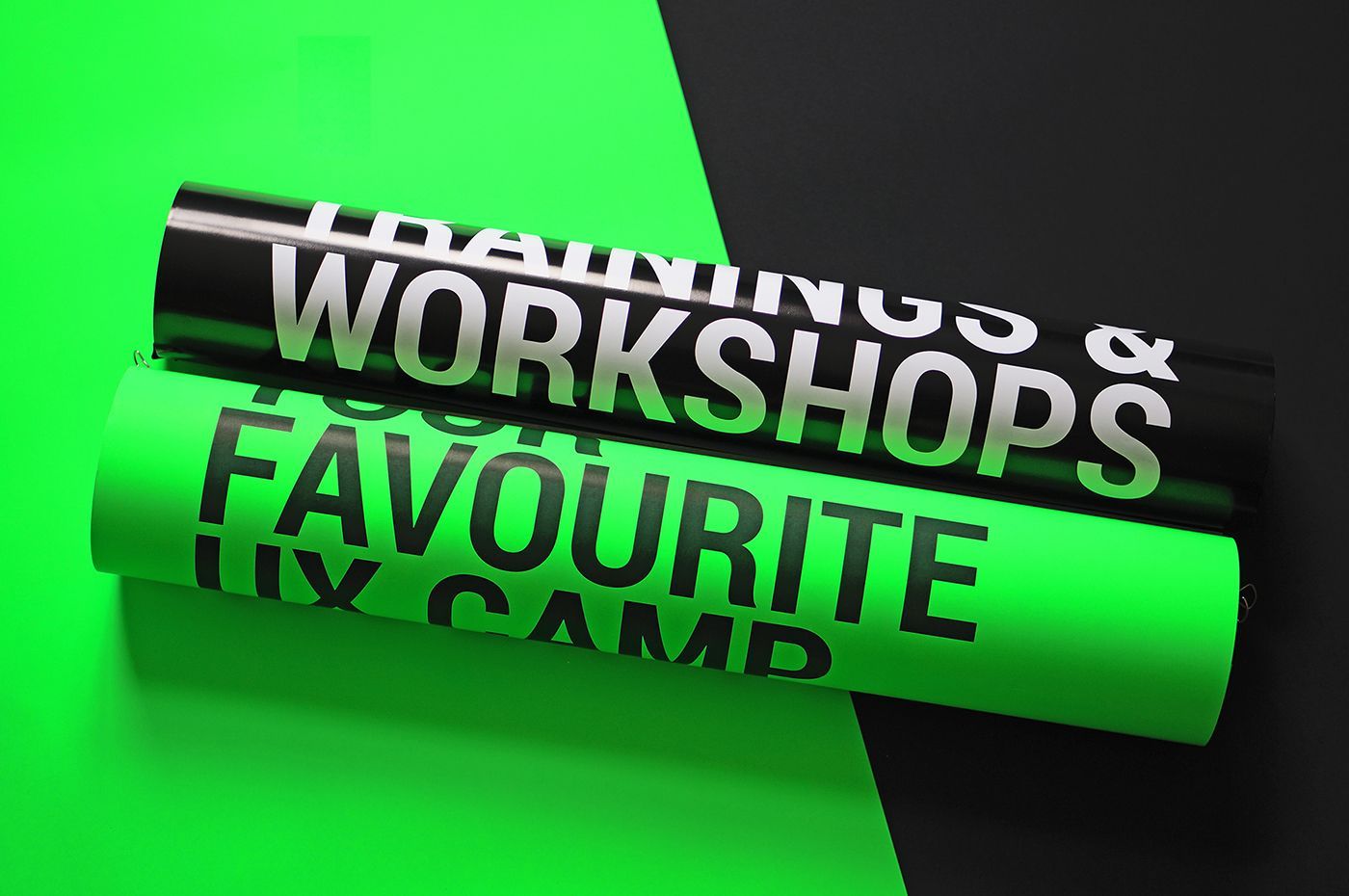 Two neon green t-shirts are stacked on top of each other on a green and black background.