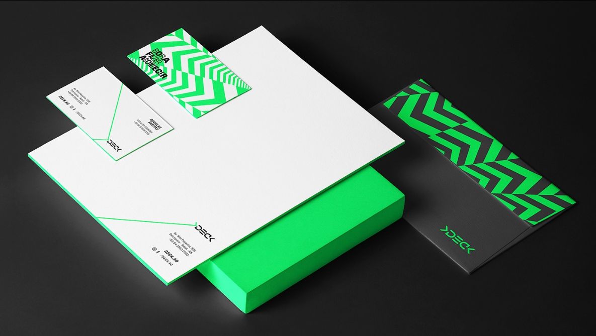A stack of green and white envelopes and business cards on a black background.