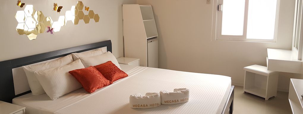 A bedroom with a large bed and a window