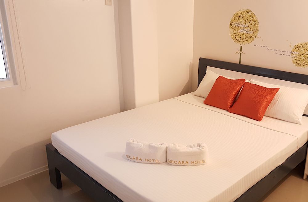 A bedroom with a bed and two towels on the bed.