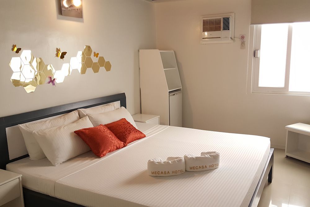 A bedroom with a large bed and a window.