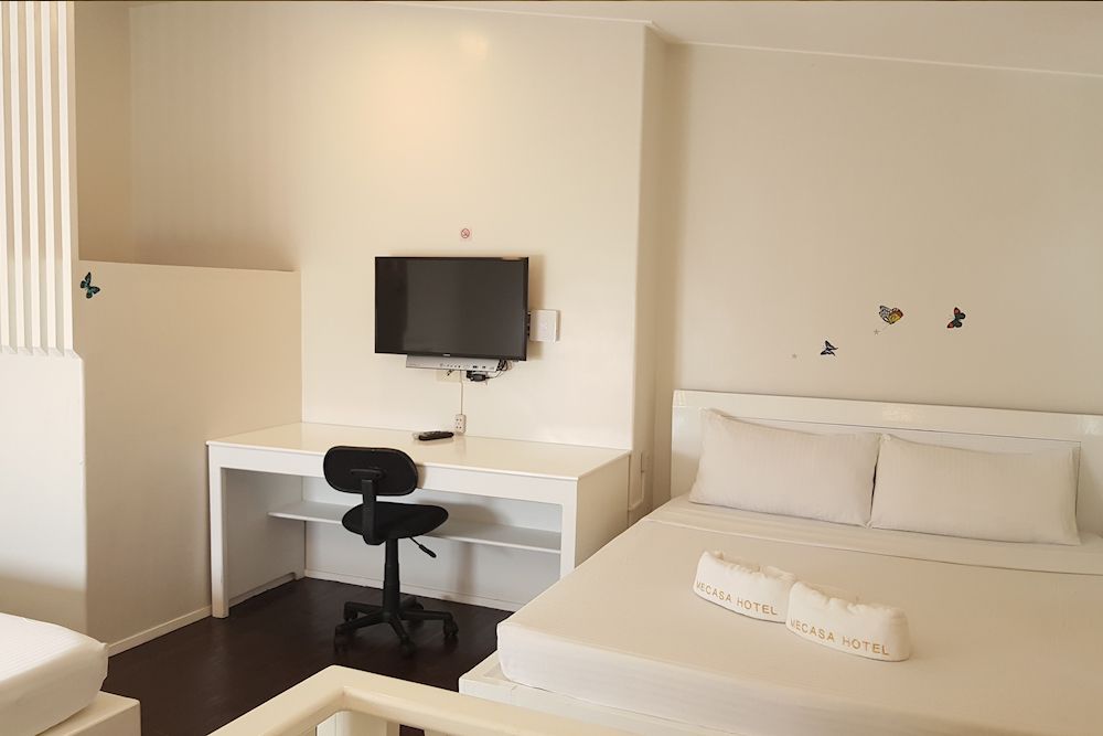 A hotel room with a bed , desk and television