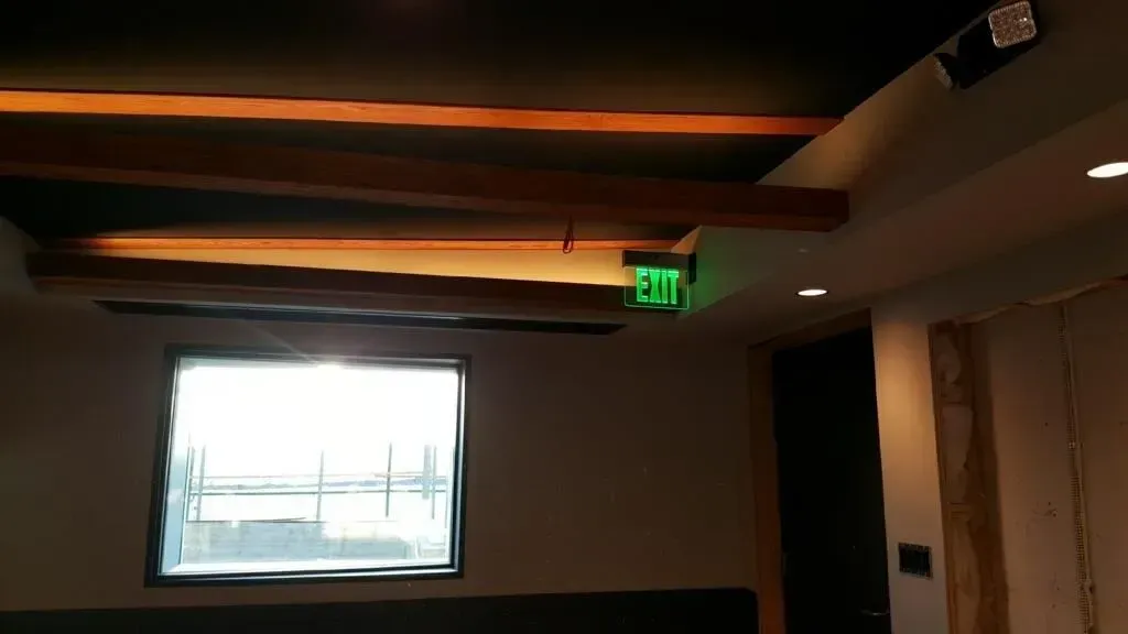 Exit sign and ceiling beam lighting in commercial space