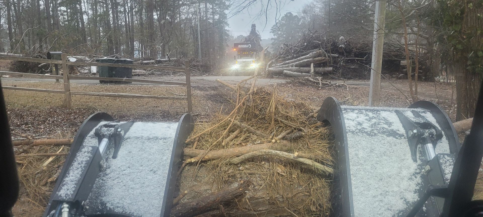A person is driving a tractor down a dirt road.