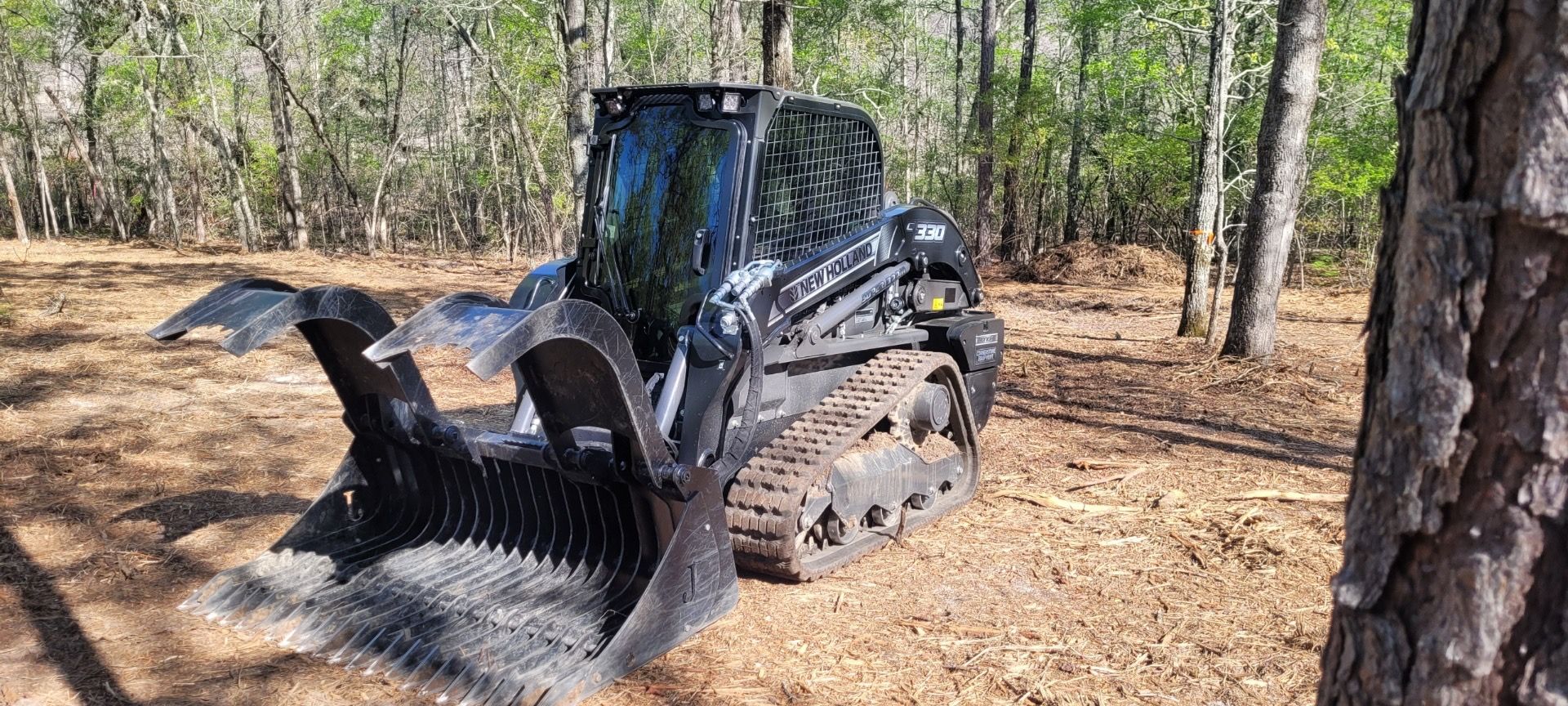 A bulldozer is sitting in the middle of a forest.