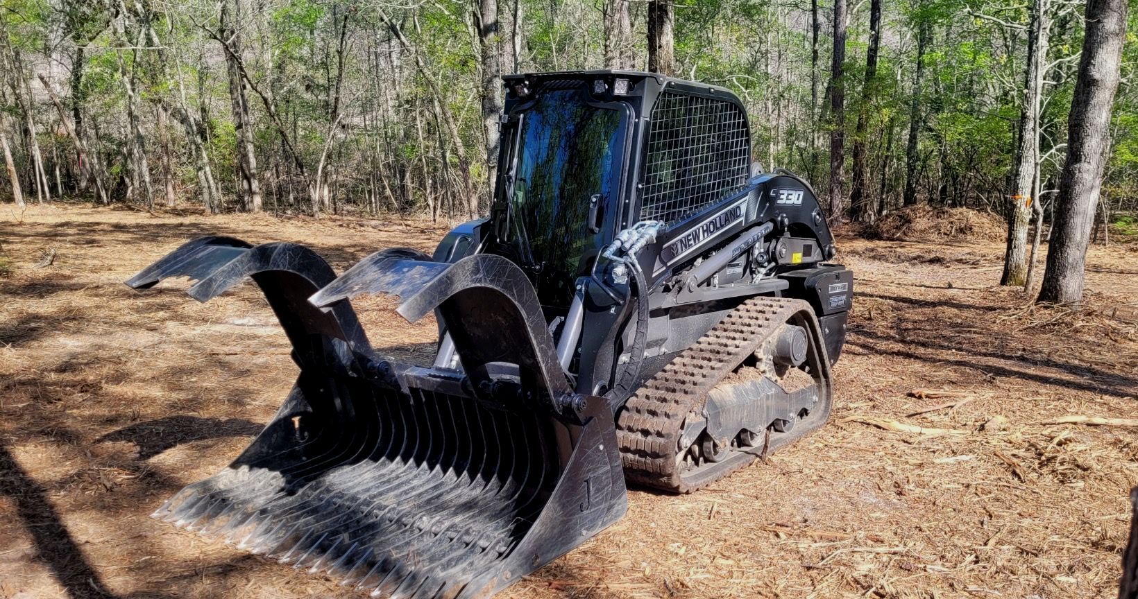 A bulldozer is sitting in the middle of a forest.