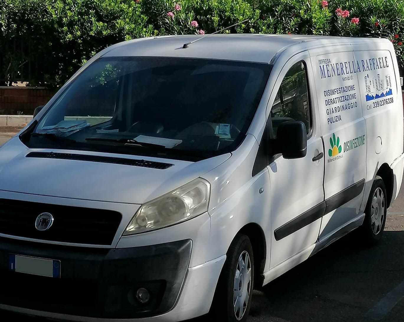 Furgone bianco per le consegne parcheggiato all'aperto, con logo sul lato.