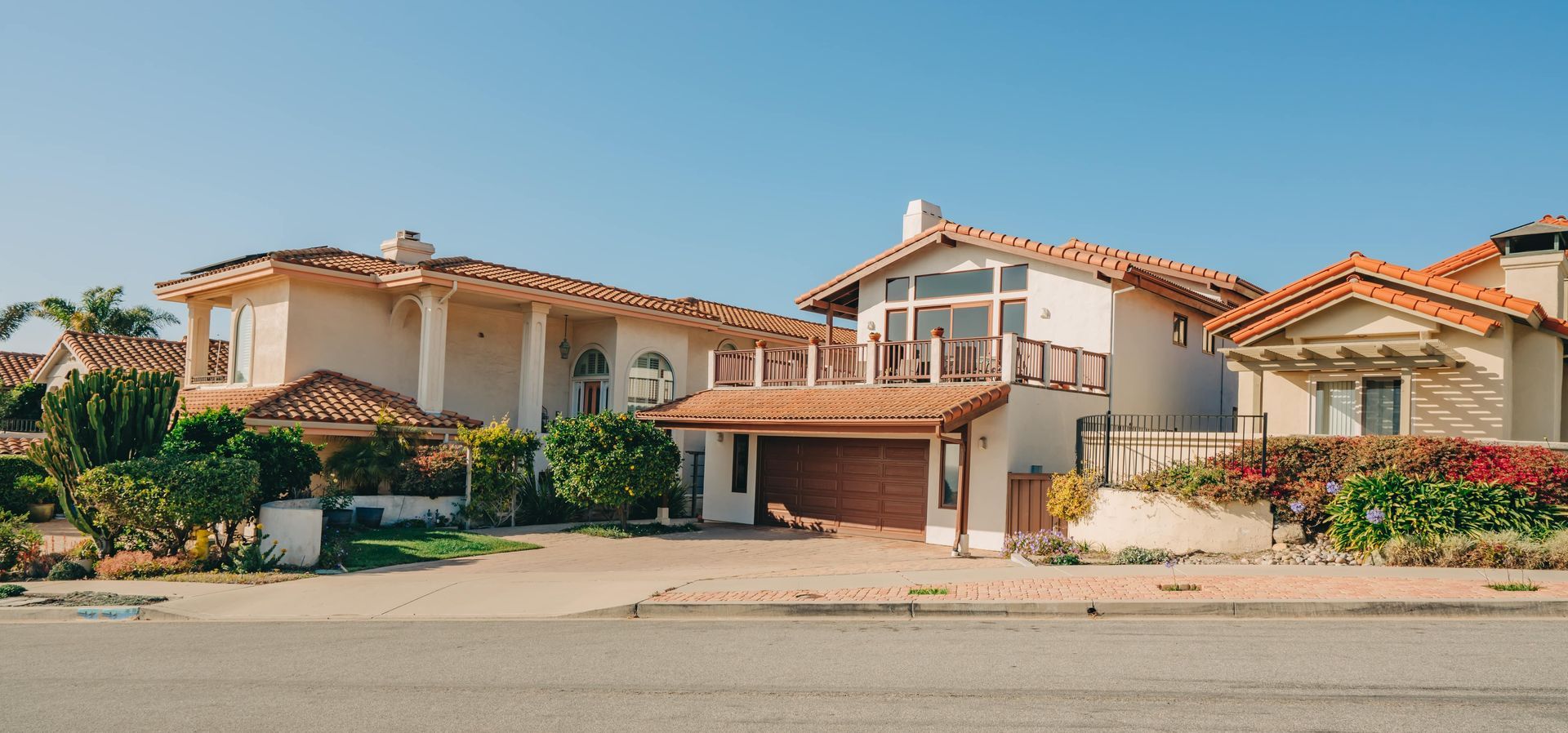 Houses with terra-cotta roofs in a sunny, coastal neighborhood.
