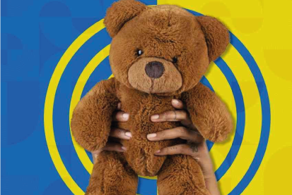 Urso de pelúcia segurado por uma pessoa em um fundo azul e amarelo