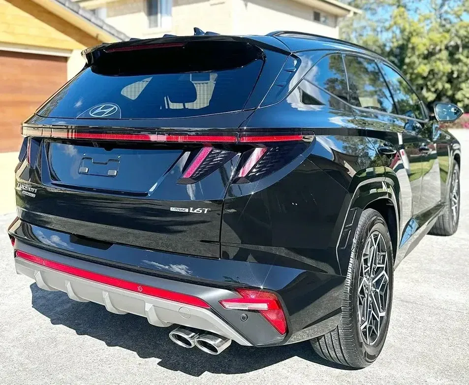 A Black Car Is Parked In Front Of A House — Remedy Mobile Car Detailing in Robina, QLD