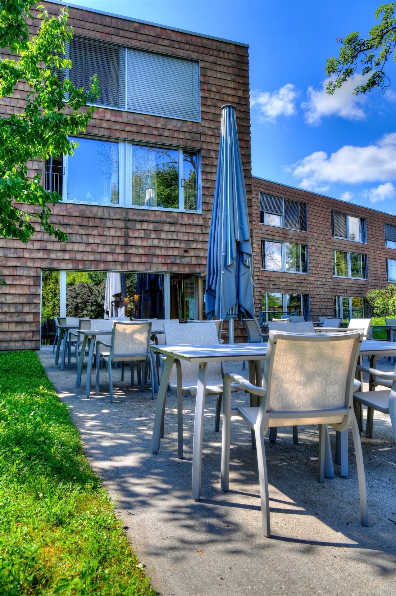 Un bâtiment en briques avec des tables et des chaises devant