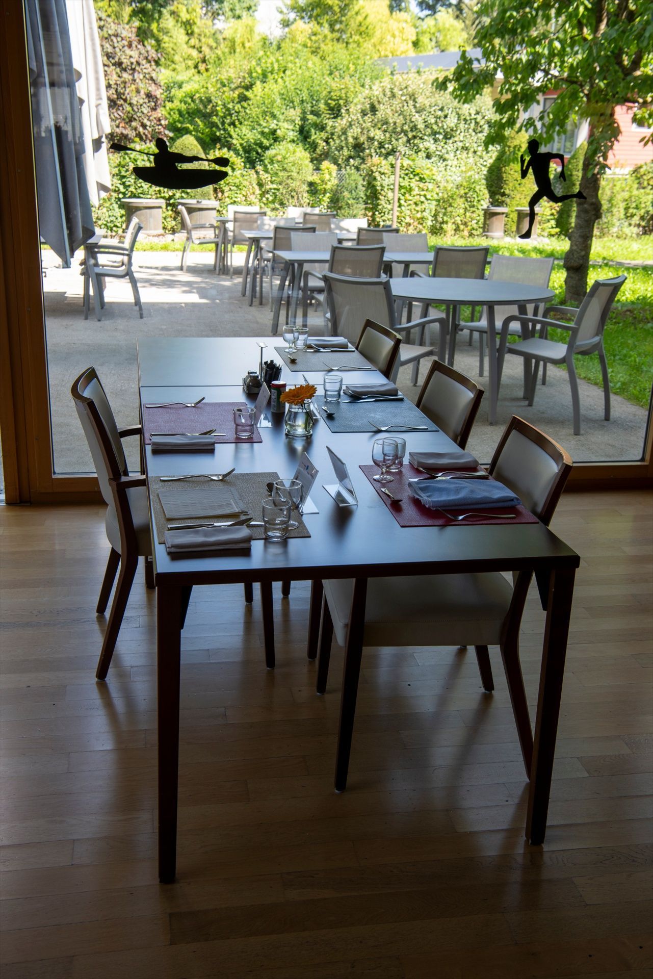 Une salle à manger avec tables et chaises et une grande fenêtre.