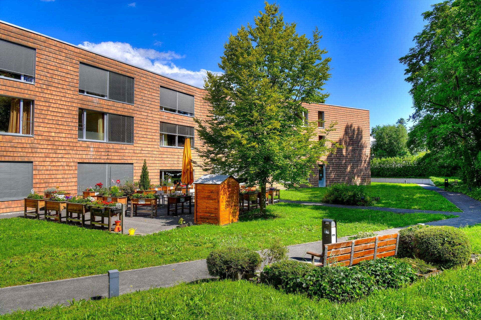 Un grand bâtiment en briques avec une pelouse verte luxuriante devant lui.