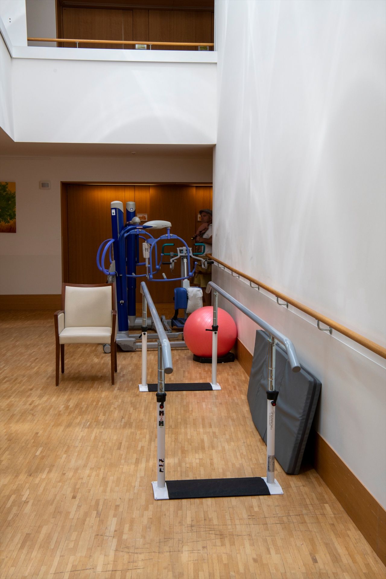 Un couloir avec une chaise, un équipement d'exercice et une balle rouge.